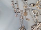 many different necklaces and bracelets that are on a table