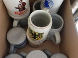 une boîte remplie de tasses à café et de mugs posée par terre