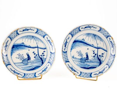 paire d'assiettes bleues et blanches ornées de personnages dans un paysage