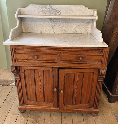 une armoire en bois avec un plateau en marbre, posée sur un parquet en bois massif