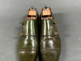 pair of olive green leather shoes with buckles on each side