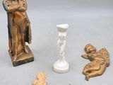 une statue représentant un homme tenant un bébé dans ses bras, à côté d'autres objets