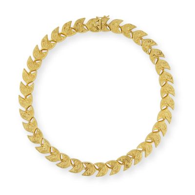 un bracelet en or orné de feuilles sur fond blanc