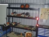 une étagère sur laquelle sont posées des chaînes et des tronçonneuses, dans un garage