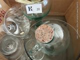 a glass table with wine glasses and a cork stopper on it