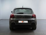 the back of a small car is parked in a large room
