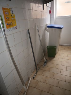 a bathroom with a trash can and a trash can on the floor