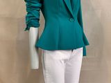 the mannequin is wearing a green jacket and white pants