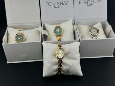 trois montres dans un coffret blanc, avec une chaîne en or et un cadran vert