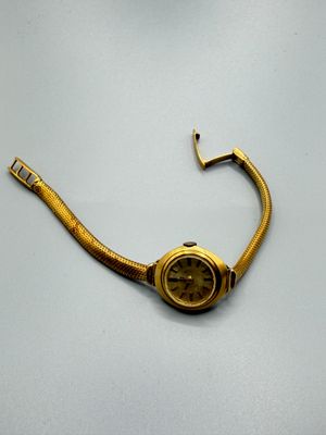 une image représentant une montre-bracelet en or dont le boîtier ressemble à un serpent