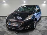 La petite voiture noire est garée dans le garage, sur le sol à damier.