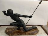 statue d'un homme agenouillé sur un socle de marbre tenant une lance