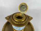a gold candle holder with a blue and white design on it