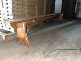 un banc en bois posé dans une pièce où se trouvent des cartons par terre