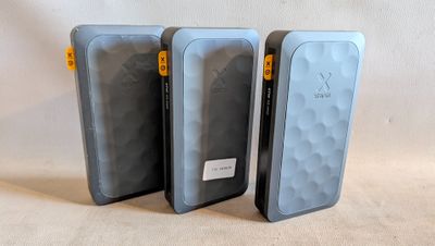 trois téléphones portables sont alignés les uns à côté des autres sur une surface blanche