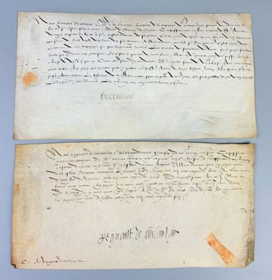 two old papers with writing on them sitting on a table