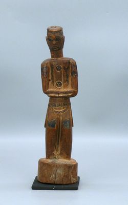 une statue en bois d'un homme avec un chapeau sur la tête