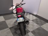 a red motorcycle parked in a room with a checkered floor