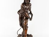 a bronze statue of a man with a helmet and a hose