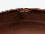 a close up of a brown bowl on a white surface