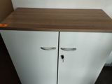 a white cabinet with two doors and a brown counter top