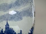 a picture of a blue and white plate with a church in the background