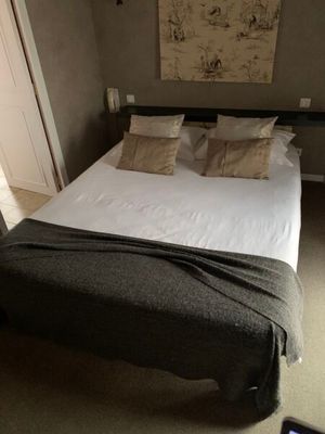 un lit recouvert d'une couverture dans une chambre