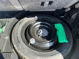 a tire with a green cloth on it in the trunk of a car