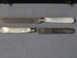two knives and a knife holder sitting on a table