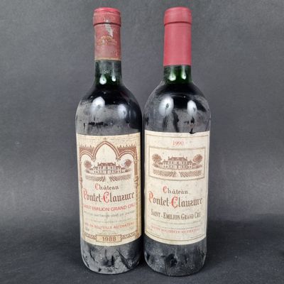 two bottles of red wine sitting next to each other on a table