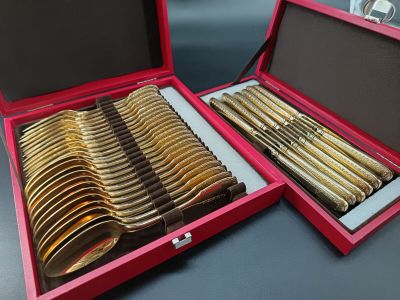 a lot of gold spoons in a red box