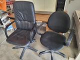 two black office chairs sitting next to each other in a room