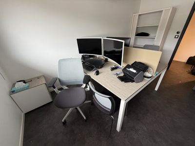 un bureau avec deux écrans d'ordinateur et une chaise placée devant