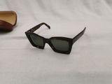 pair of sunglasses on a white surface with a pair of glasses in the background