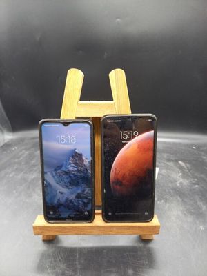 Deux téléphones portables sont posés sur un support en bois, sur une table.