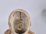 a small figurine of a woman holding a cup