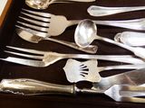 un lot de cuillères et fourchettes en argent dans une boîte