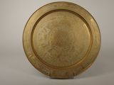 an image of a gold plate on a stand on a white background