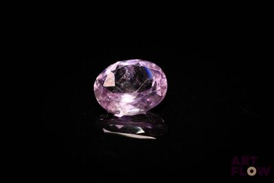 a close up of a pink diamond on a black surface