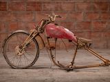 a very old motorcycle that is sitting in front of a brick wall