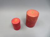 deux boîtes rouges posées sur une table, sur fond blanc