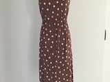 robe à pois marron et blancs sur un présentoir pour mannequin