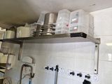 de nombreuses casseroles et poêles sur les étagères de la cuisine