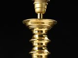 a close up of a gold colored candle holder on a black background