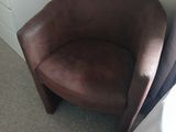 a brown leather chair in a corner of a room