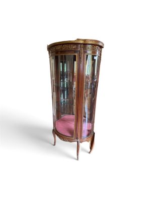 une vitrine en verre avec un coussin rose au fond