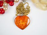 a heart shaped pendant with a horse on it