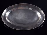 une assiette ancienne en argent ornée d'une couronne sur fond noir