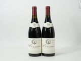 two bottles of red wine sitting next to each other on a white surface