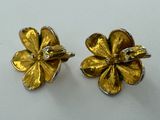 a pair of gold flower earrings with diamonds on them